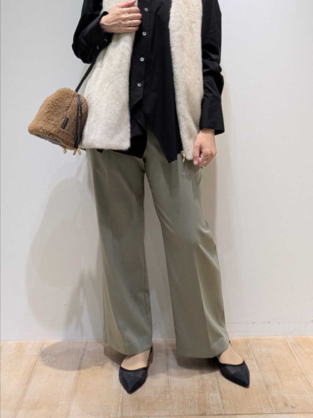 ブラック系のシャツ/ブラウス、ホワイト系のベスト、グリーン系のその他パンツを着用したレディースの秋コーディネートの3枚目の写真