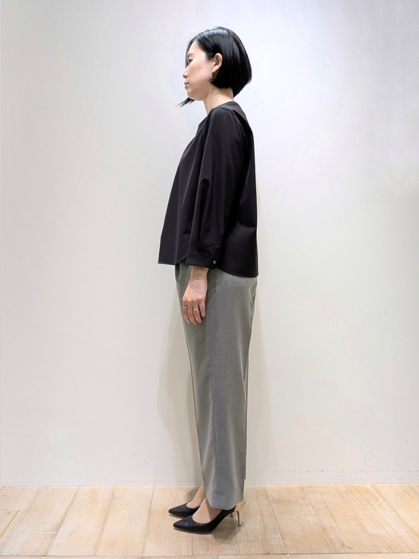 ブラック系のシャツ/ブラウス、グレー系のスラックスを着用したレディースの春コーディネートの2枚目の写真