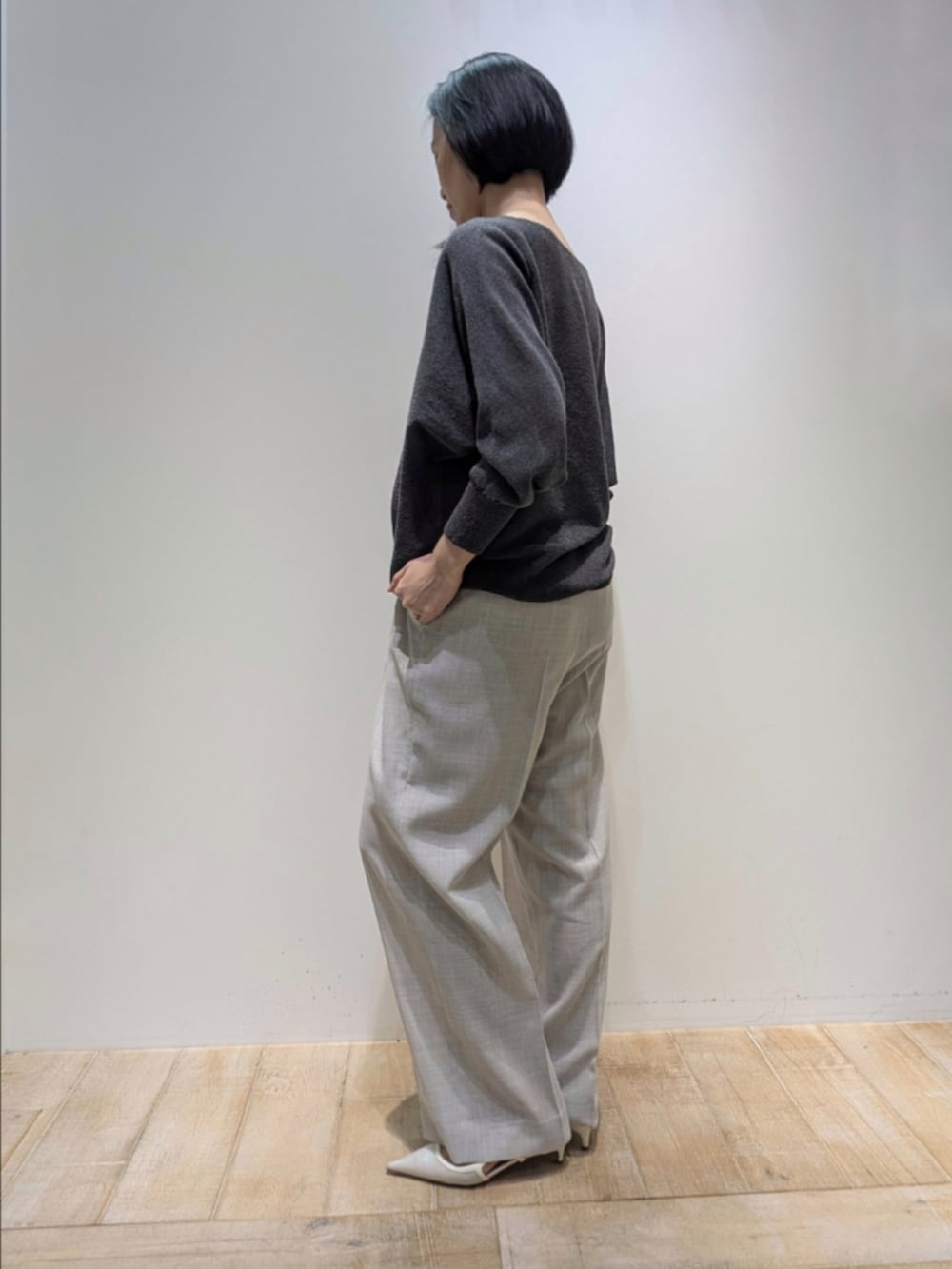 グレー系のニット/セーター、ベージュ系のその他パンツ、シルバー系のネックレスを着用したレディースの春コーディネートの4枚目の写真