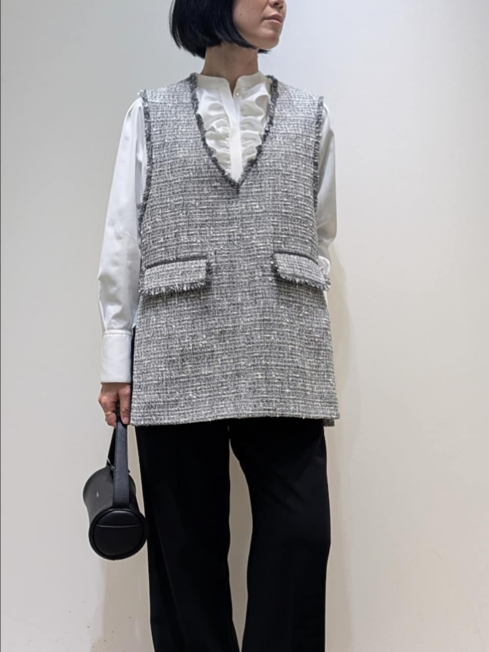 ブラック系のベスト、ホワイト系のシャツ/ブラウス、ブラック系のその他パンツを着用したレディースの冬コーディネートの2枚目の写真