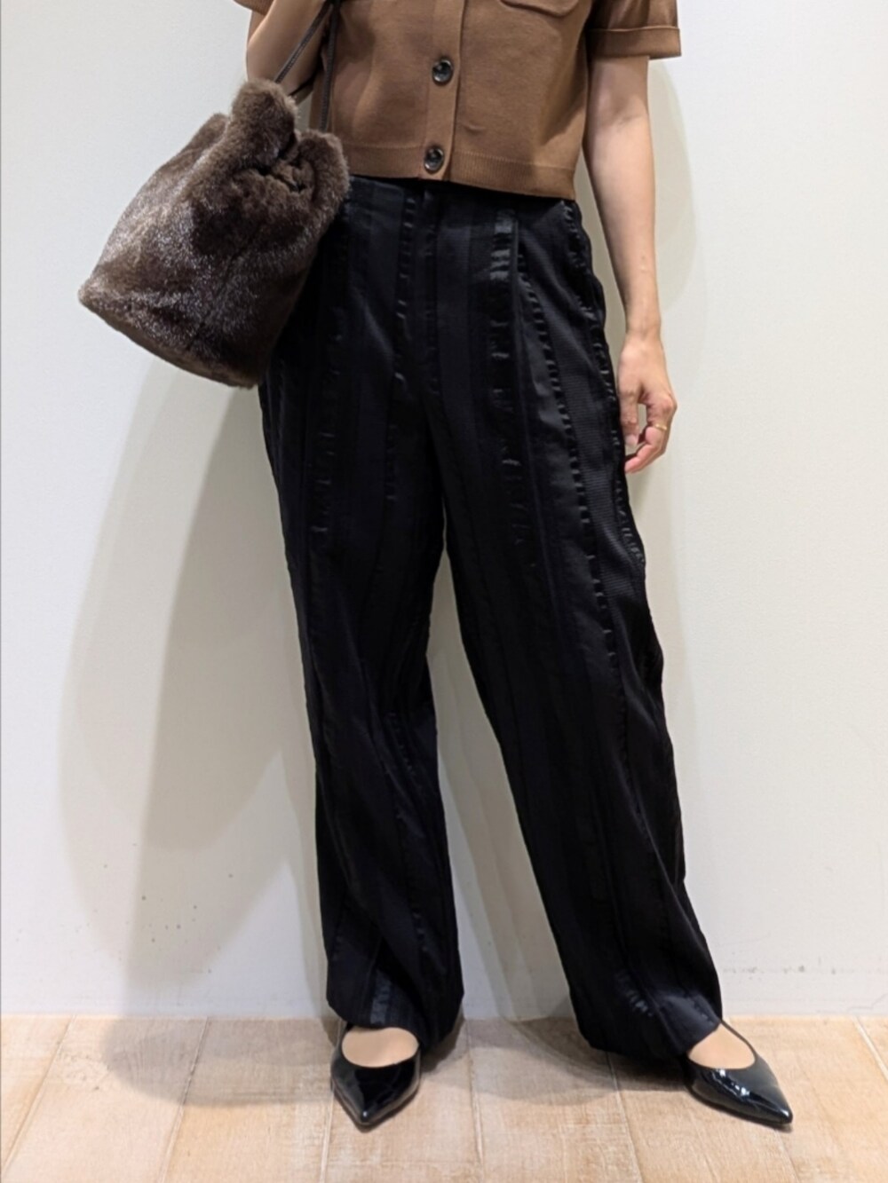 ブラウン系のTシャツ/カットソー、ブラック系のその他パンツ、ブラウン系のショルダーバッグを着用したレディースの秋コーディネートの3枚目の写真