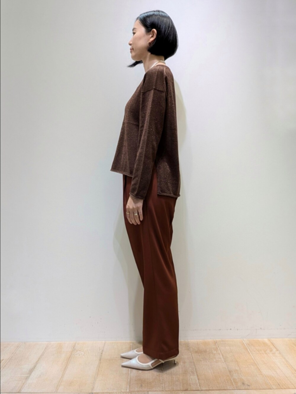 ブラウン系のその他パンツ、その他のニット/セーター、ホワイト系のネックレスを着用したレディースの秋コーディネートの4枚目の写真
