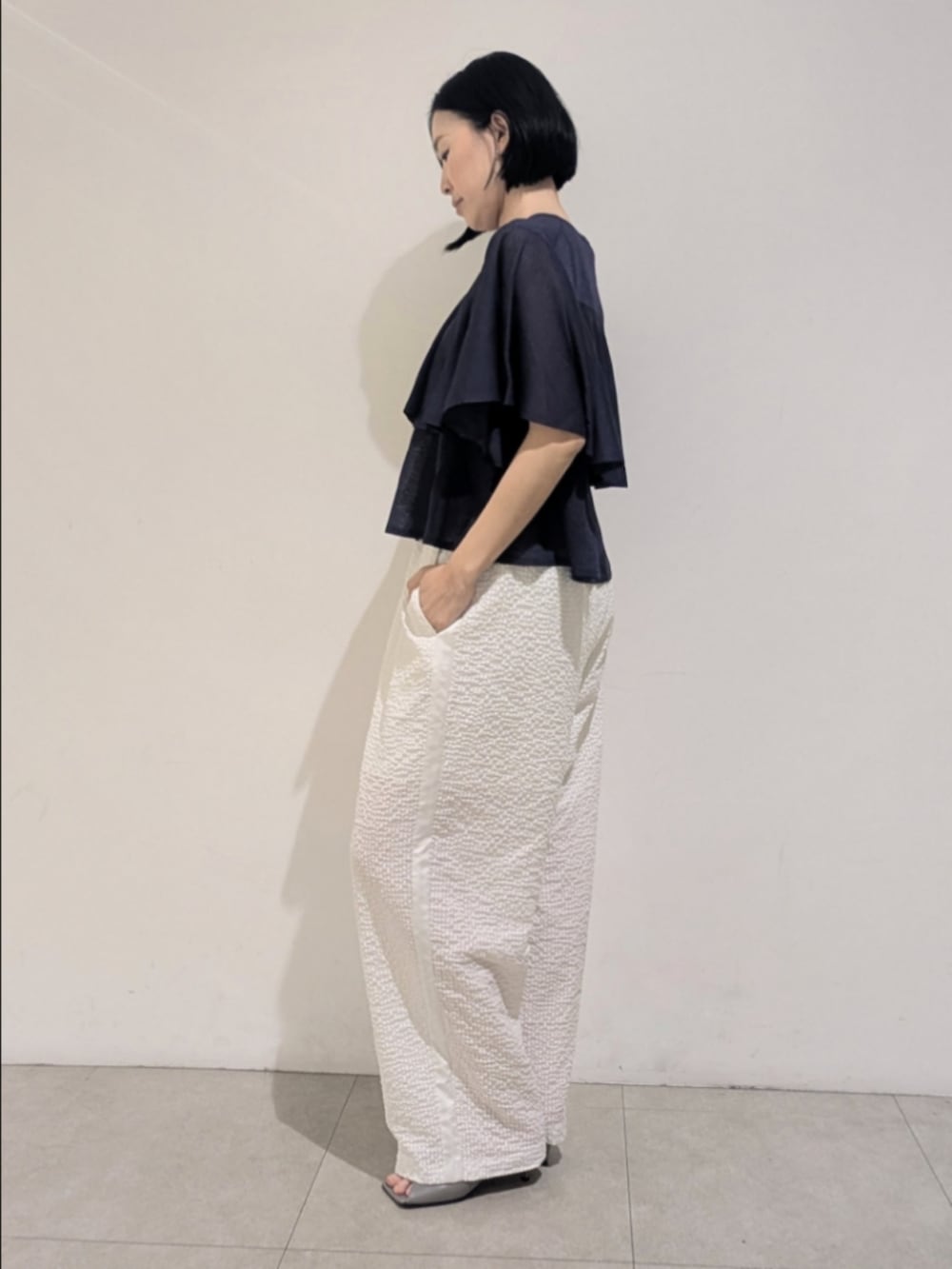 ブルー系のニット/セーター、ホワイト系のその他パンツ、シルバー系のネックレスを着用したレディースの夏コーディネートの4枚目の写真