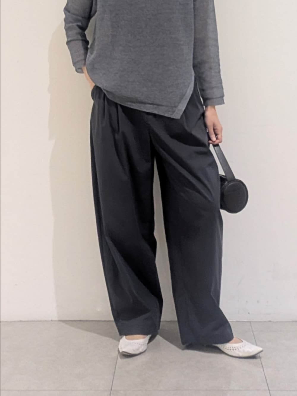 ブルー系のニット/セーター、グレー系のその他パンツ、シルバー系のネックレスを着用したレディースの夏コーディネートの3枚目の写真