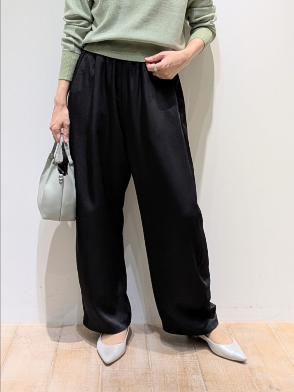 グリーン系のニット/セーター、ブラック系のその他パンツを着用したレディースの秋コーディネートの3枚目の写真