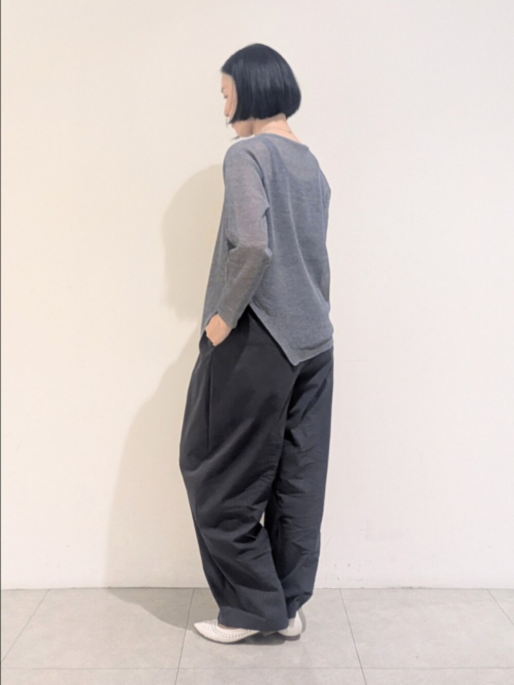 ブルー系のニット/セーター、グレー系のその他パンツ、シルバー系のネックレスを着用したレディースの夏コーディネートの4枚目の写真
