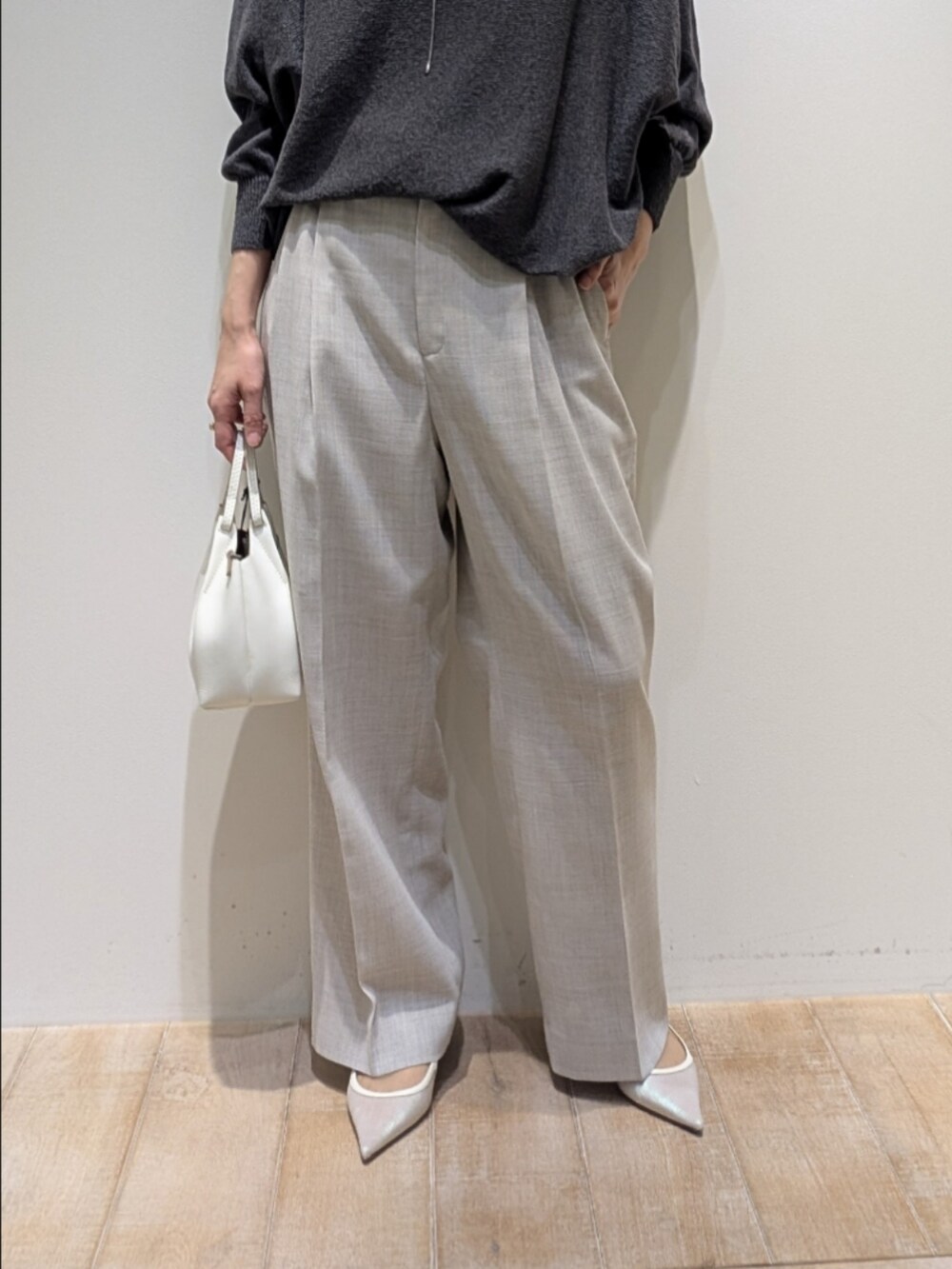 グレー系のニット/セーター、ベージュ系のその他パンツ、シルバー系のネックレスを着用したレディースの春コーディネートの3枚目の写真