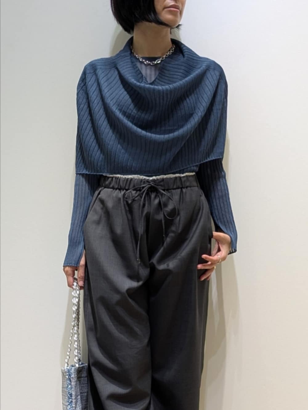 ブルー系のニット/セーター、グレー系のその他パンツ、シルバー系のトートバッグを着用したレディースの秋コーディネートの2枚目の写真