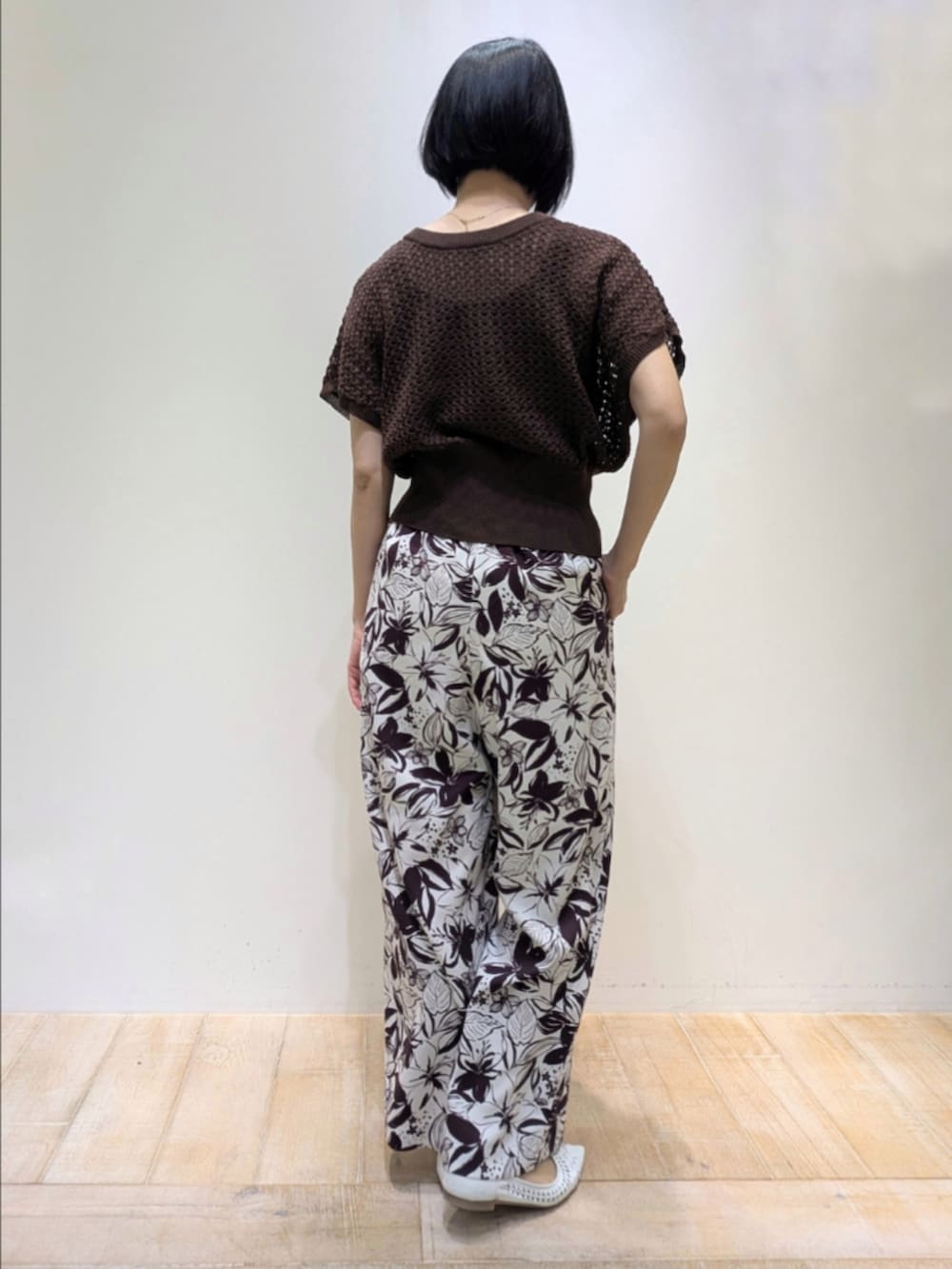 ブラウン系のニット/セーター、レッド系のその他パンツ、ゴールド系のショルダーバッグを着用したレディースの春コーディネートの5枚目の写真