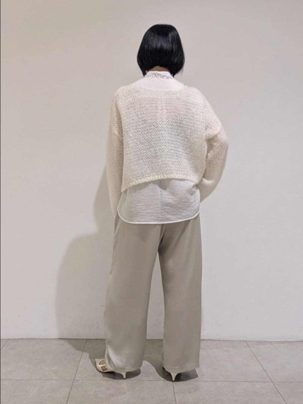 ホワイト系のニット/セーター、ホワイト系のシャツ/ブラウス、ベージュ系のその他パンツを着用したレディースの秋コーディネートの5枚目の写真