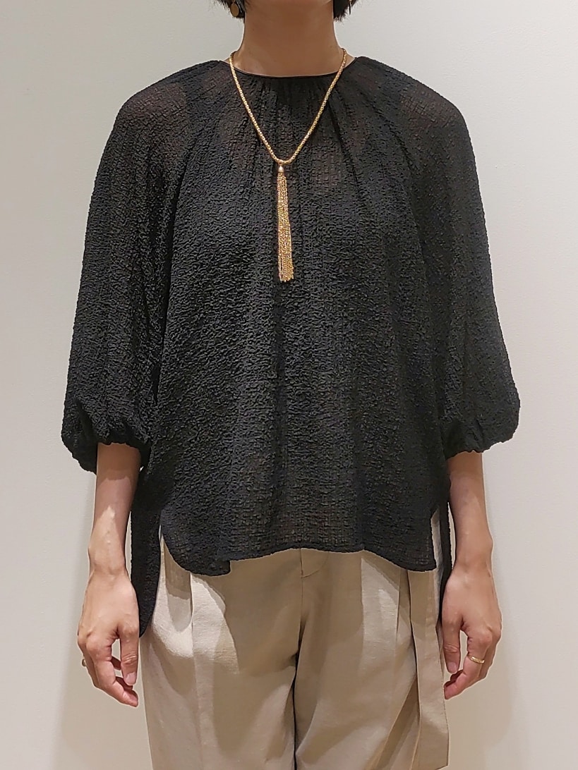 ブラック系のシャツ/ブラウス、ベージュ系のスラックスを着用したレディースの夏コーディネートの2枚目の写真