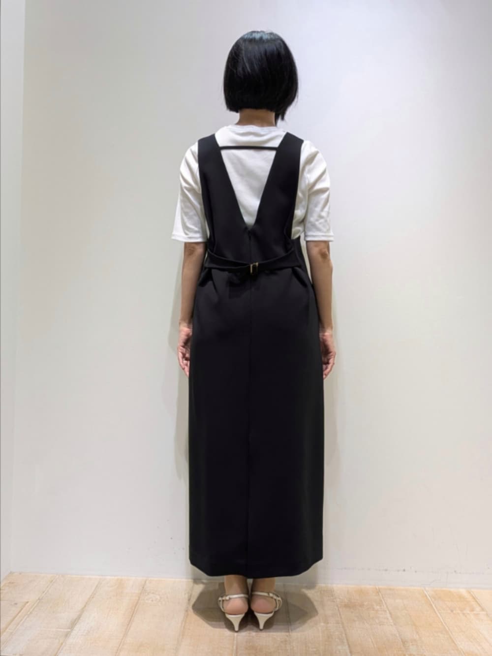 ホワイト系のTシャツ/カットソー、ブラック系のワンピース、ゴールド系のネックレスを着用したレディースの秋コーディネートの4枚目の写真