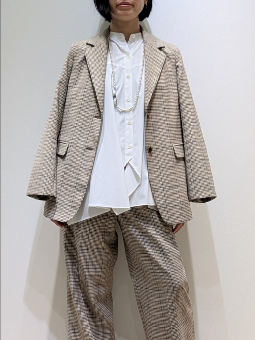 ベージュ系のテーラードジャケット、ホワイト系のシャツ/ブラウス、ベージュ系のその他パンツを着用したレディースの秋コーディネートの2枚目の写真
