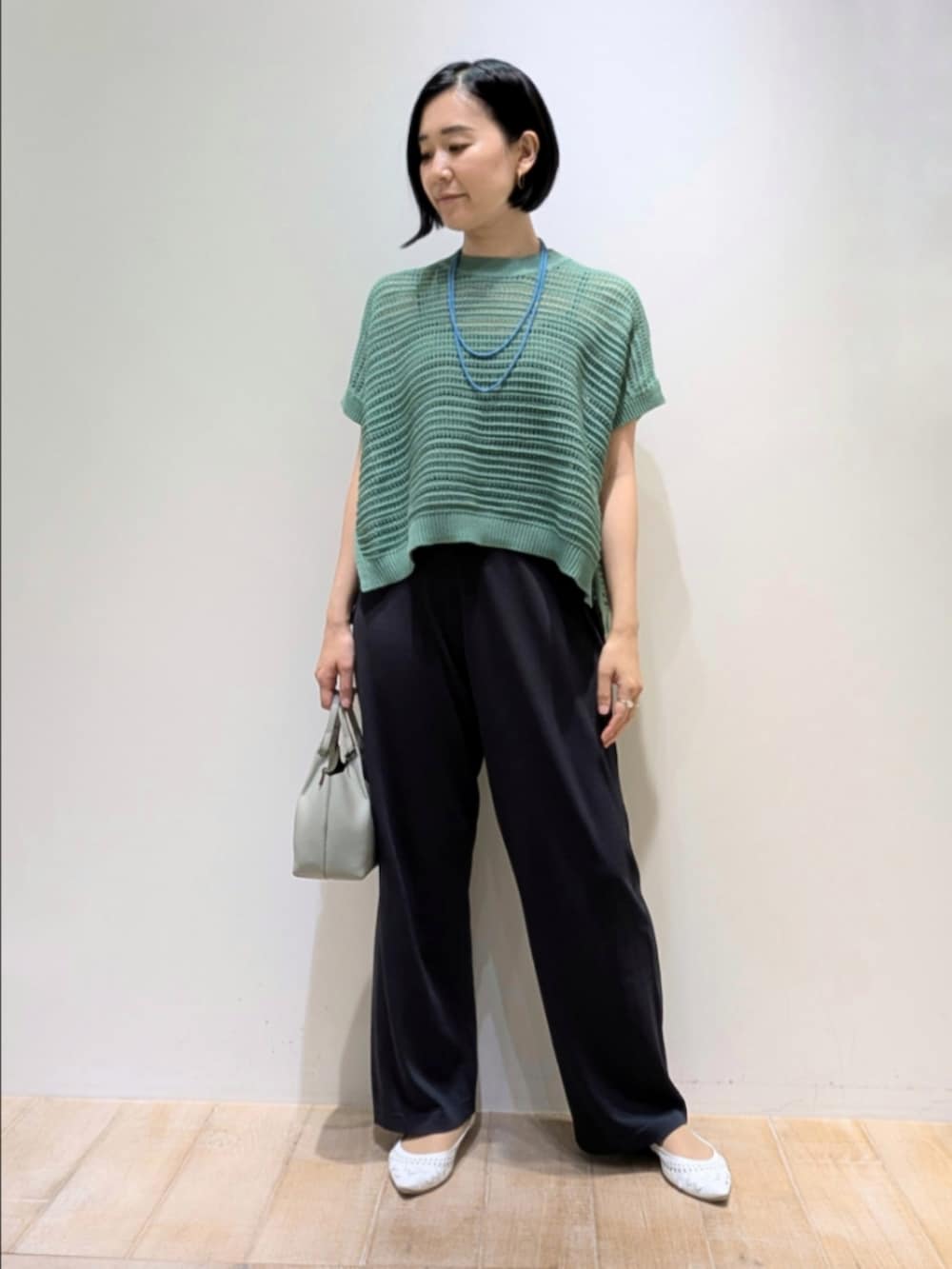 グリーン系のニット/セーター、グレー系のその他パンツを着用したレディースの夏コーディネートの5枚目の写真