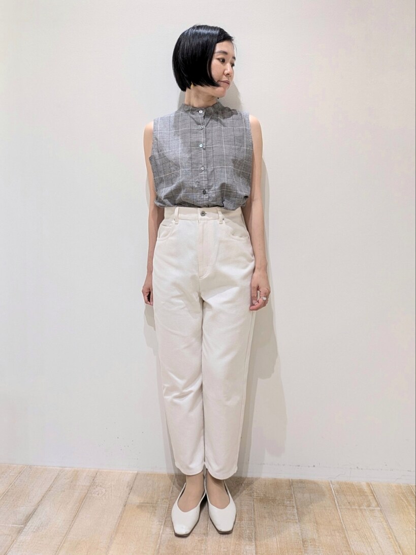 ブラック系のタンクトップ、ホワイト系のデニムパンツを着用したレディースの夏コーディネートの5枚目の写真