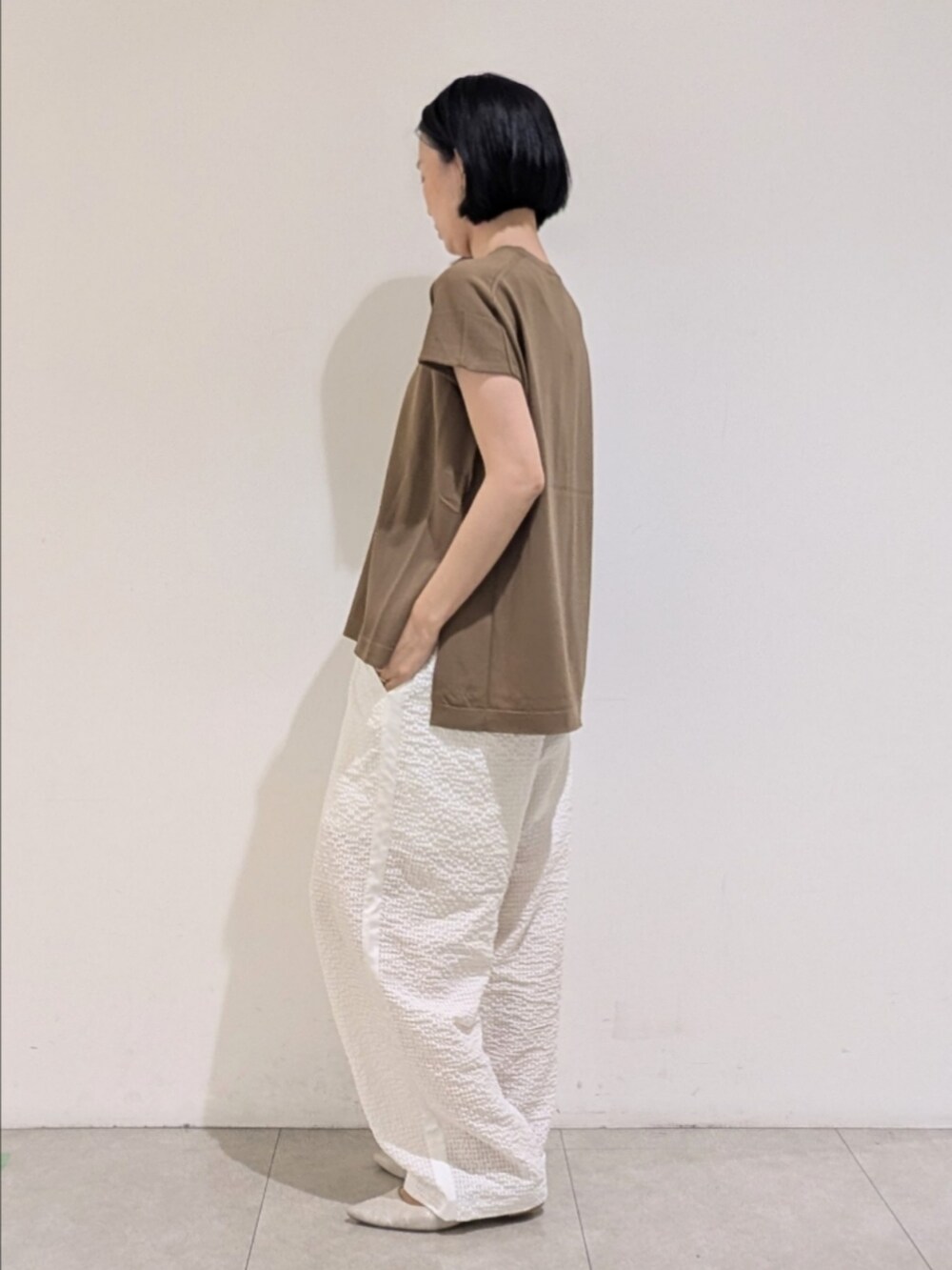 グレー系のニット/セーター、ホワイト系のその他パンツ、ゴールド系のネックレスを着用したレディースの夏コーディネートの4枚目の写真