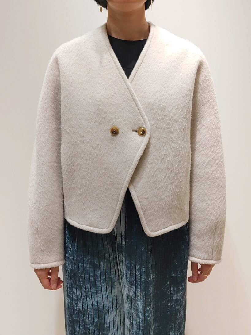 ベージュ系のノーカラーコート、ブルー系のその他パンツ、ブラック系のシャツ/ブラウスを着用したレディースの冬コーディネートの2枚目の写真