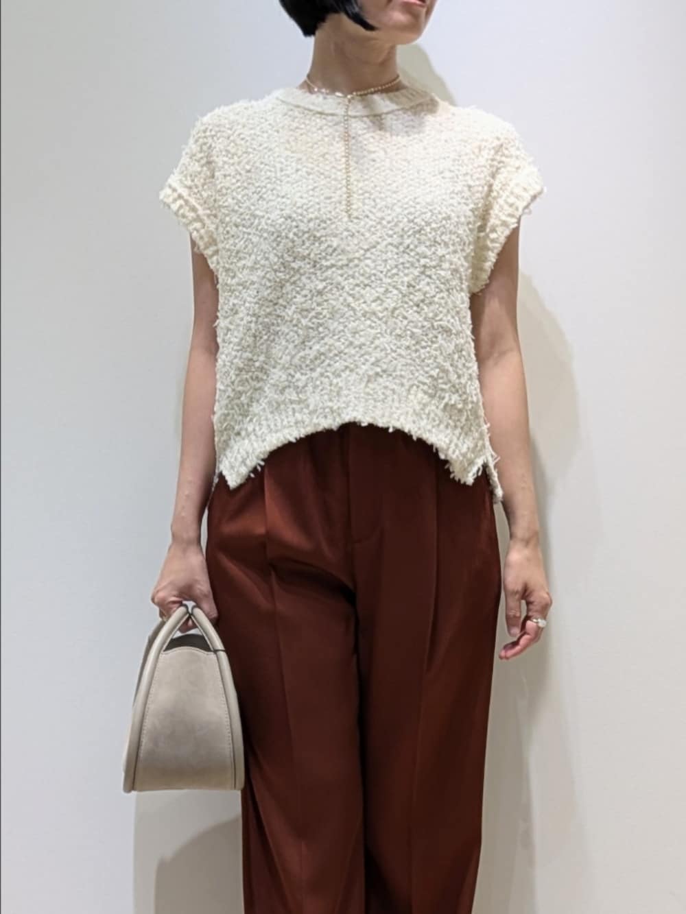 ホワイト系のニット/セーター、ブラウン系のその他パンツを着用したレディースの夏コーディネートの2枚目の写真