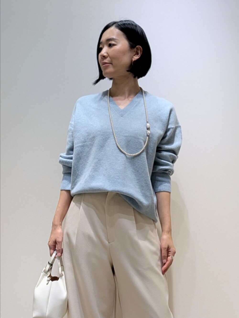 ブルー系のニット/セーター、ホワイト系のその他パンツを着用したレディースの冬コーディネートの2枚目の写真