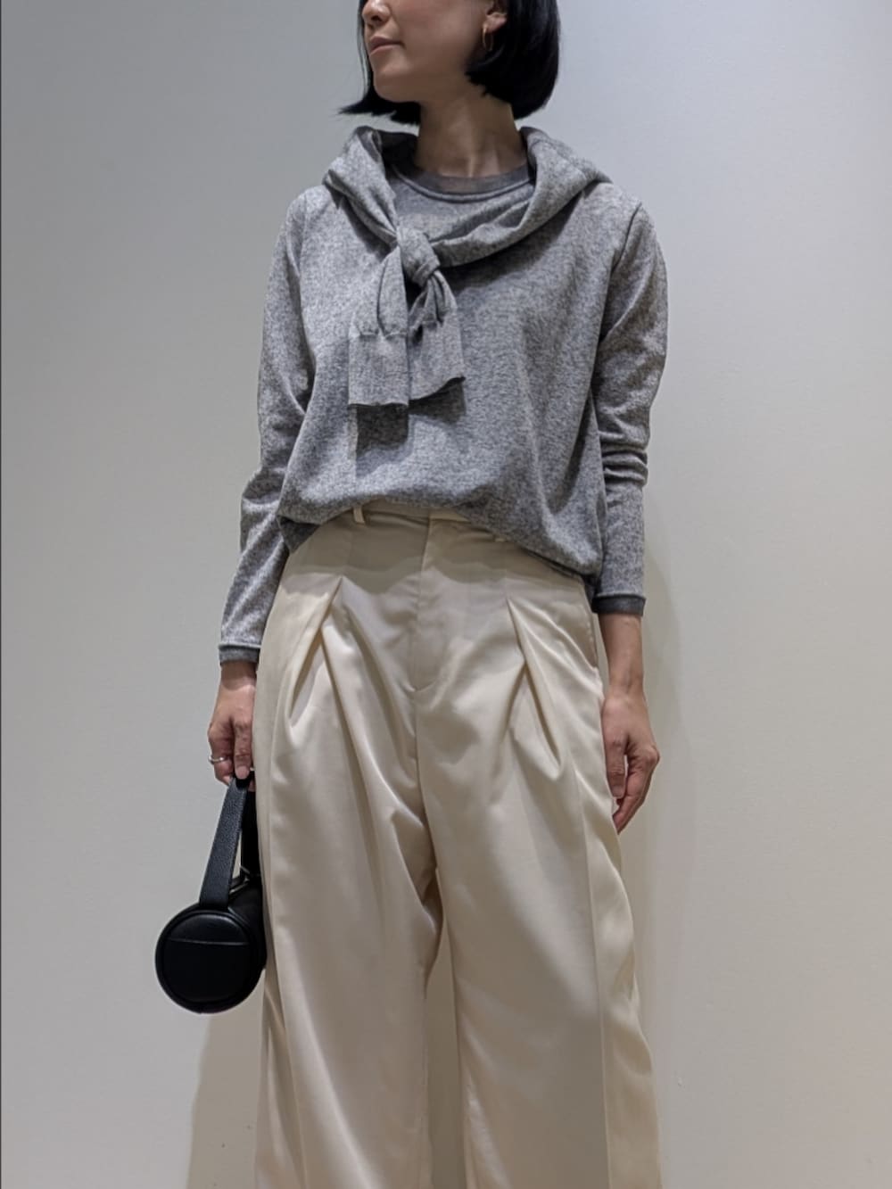 グレー系のニット/セーター、グレー系のカーディガン/ボレロ、ホワイト系のその他パンツを着用したレディースの春コーディネートの2枚目の写真