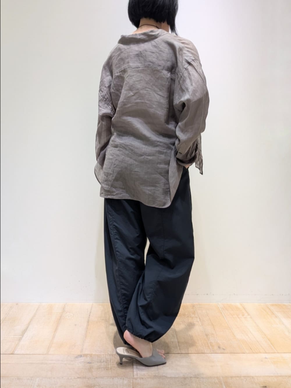 ブラウン系のシャツ/ブラウス、グレー系のその他パンツ、ゴールド系のネックレスを着用したレディースの春コーディネートの5枚目の写真