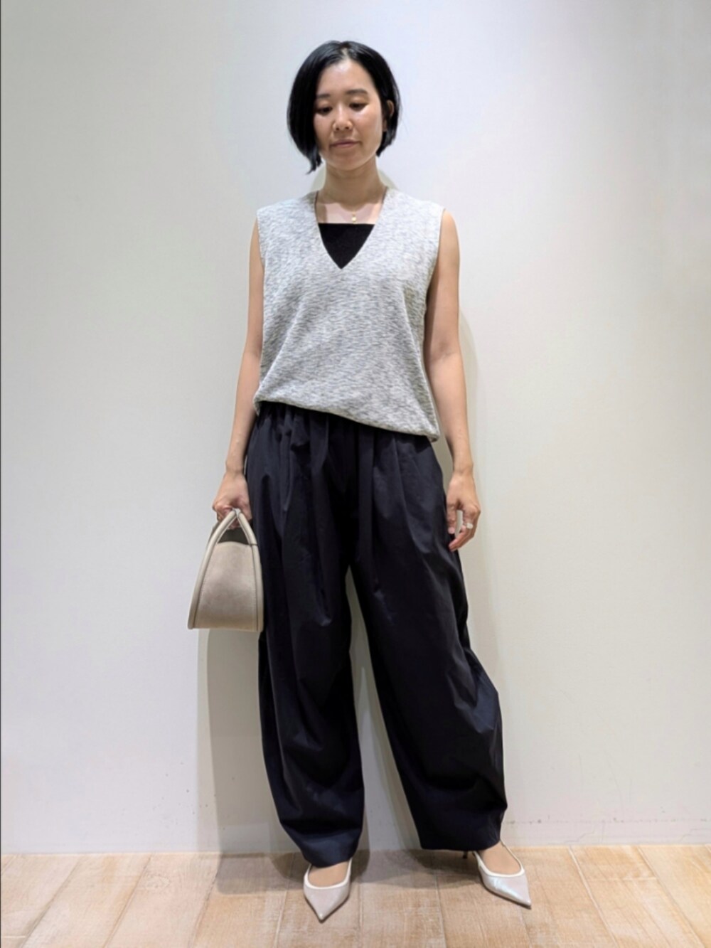 グレー系のベスト、ブラック系のタンクトップ、ブルー系のカーゴパンツを着用したレディースの夏コーディネートの6枚目の写真