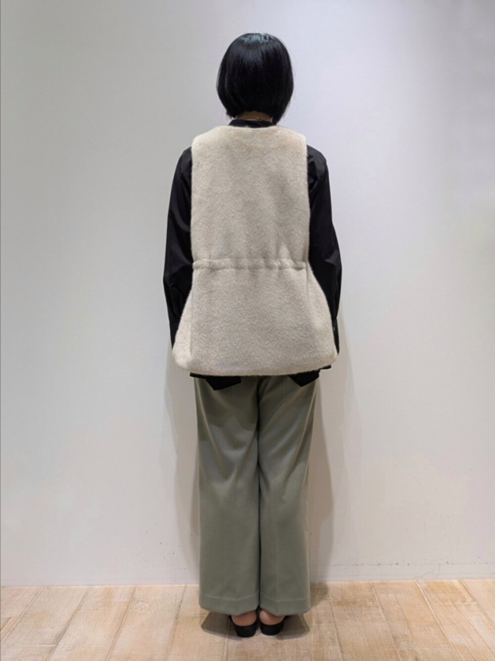 ブラック系のシャツ/ブラウス、ホワイト系のベスト、グリーン系のその他パンツを着用したレディースの秋コーディネートの5枚目の写真