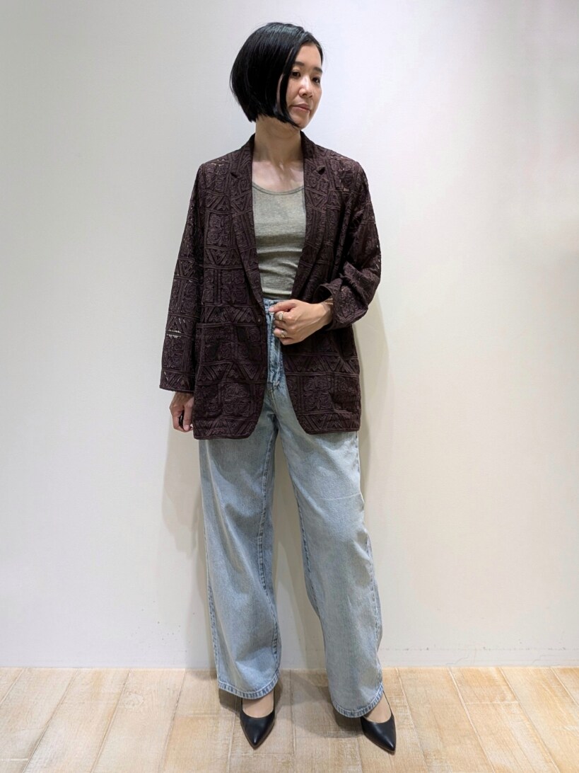 ブラウン系のテーラードジャケット、ベージュ系のタンクトップ、ブルー系のデニムパンツを着用したレディースの夏コーディネートの6枚目の写真