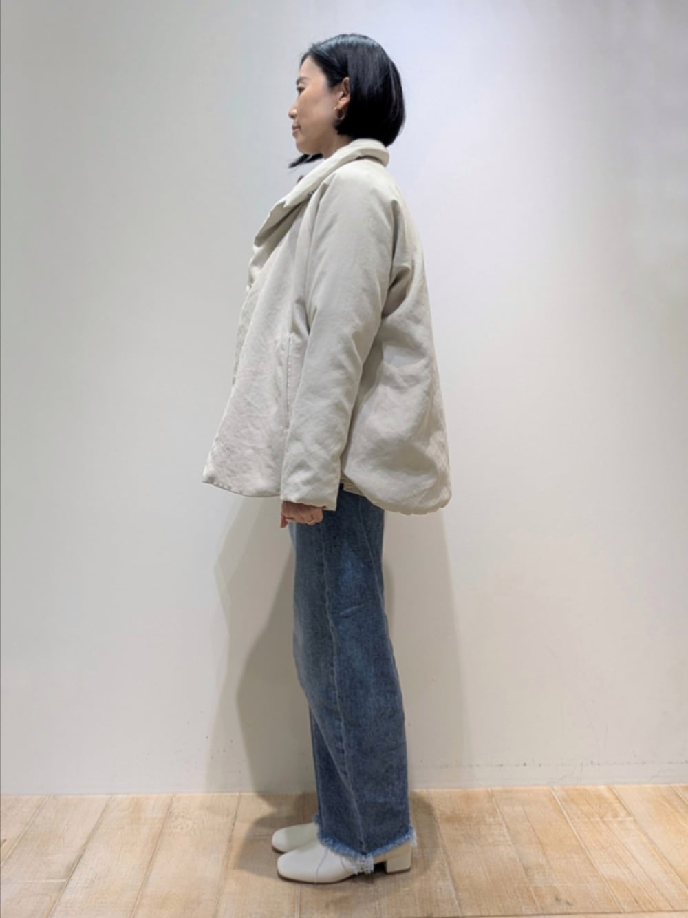 ベージュ系のダウンジャケット/コート、レッド系のニット/セーター、ホワイト系のシャツ/ブラウスを着用したレディースの秋コーディネートの4枚目の写真