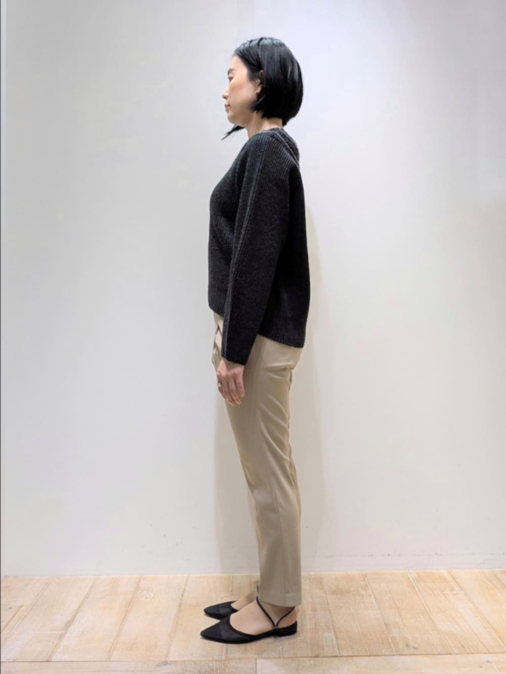 グレー系のニット/セーター、ベージュ系のその他パンツ、ブラウン系のショルダーバッグを着用したレディースの秋コーディネートの4枚目の写真