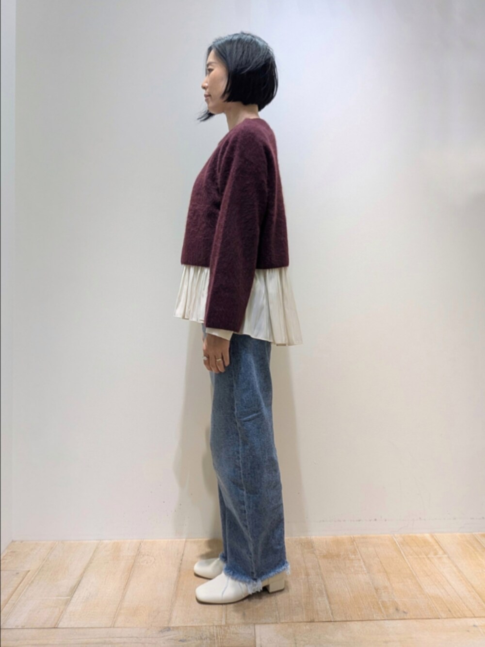 レッド系のニット/セーター、ホワイト系のシャツ/ブラウスを着用したレディースの冬コーディネートの4枚目の写真