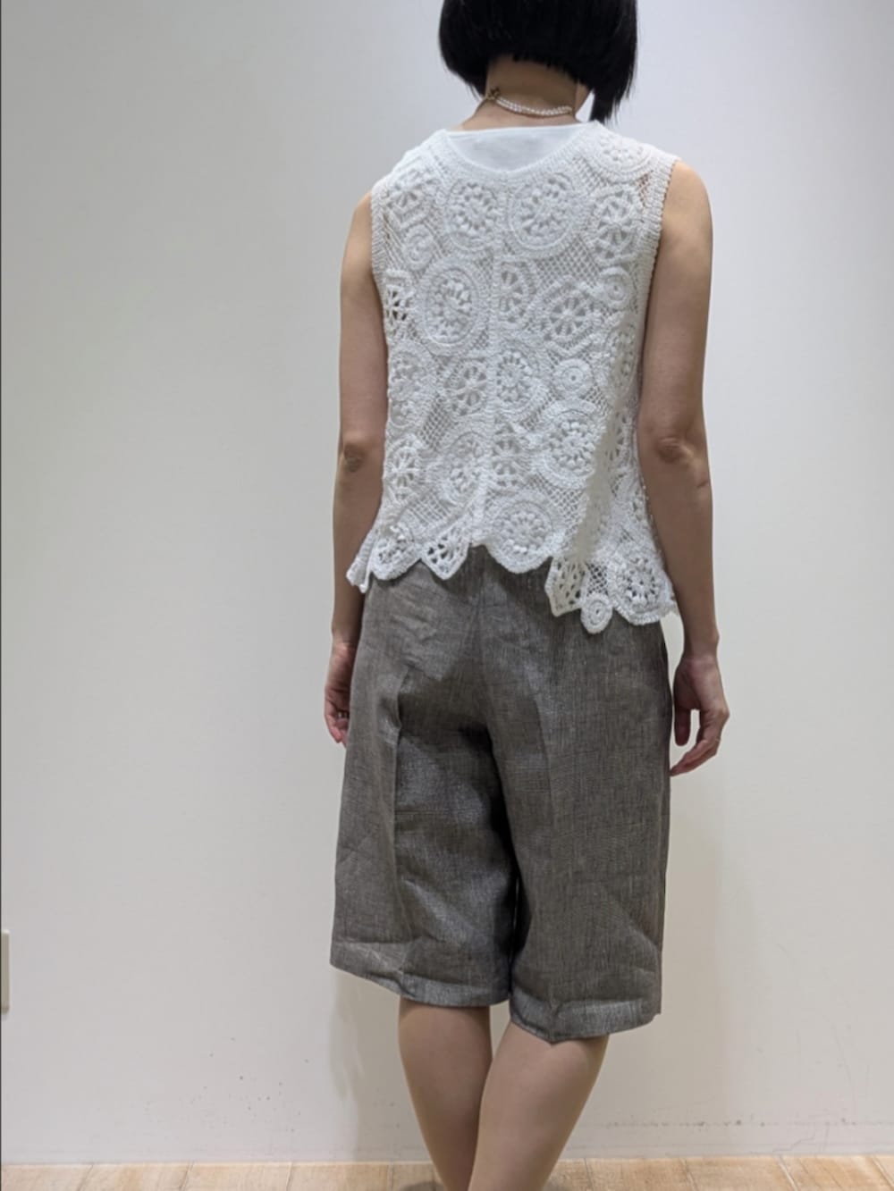 ホワイト系のタンクトップ、ホワイト系のベスト、ベージュ系のその他パンツを着用したレディースの春コーディネートの5枚目の写真