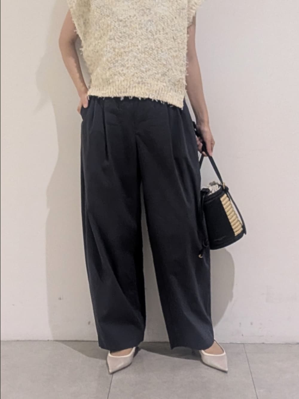 ホワイト系のニット/セーター、グレー系のその他パンツ、ゴールド系のネックレスを着用したレディースの夏コーディネートの3枚目の写真