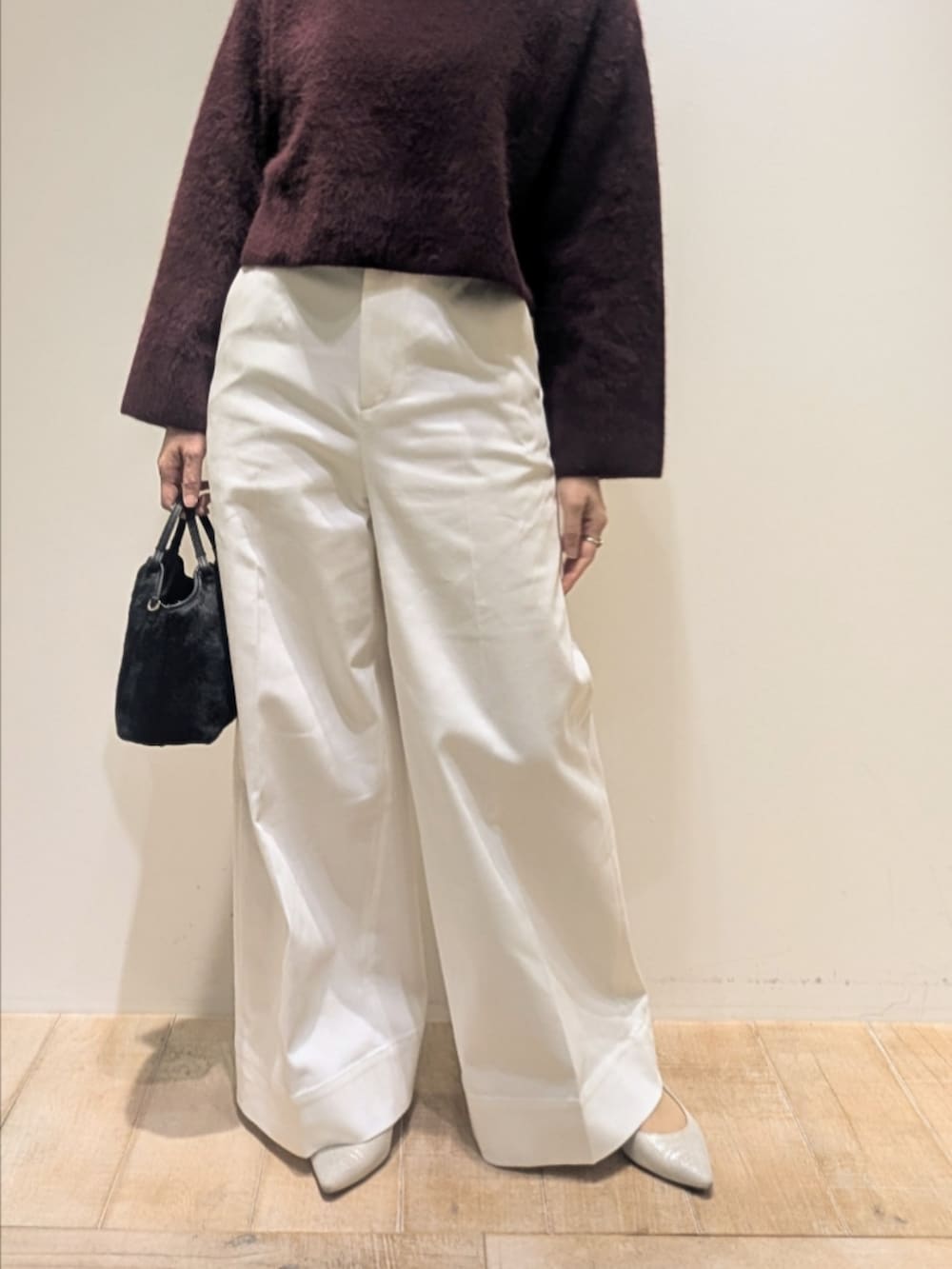 レッド系のニット/セーター、ホワイト系のデニムパンツを着用したレディースの冬コーディネートの2枚目の写真