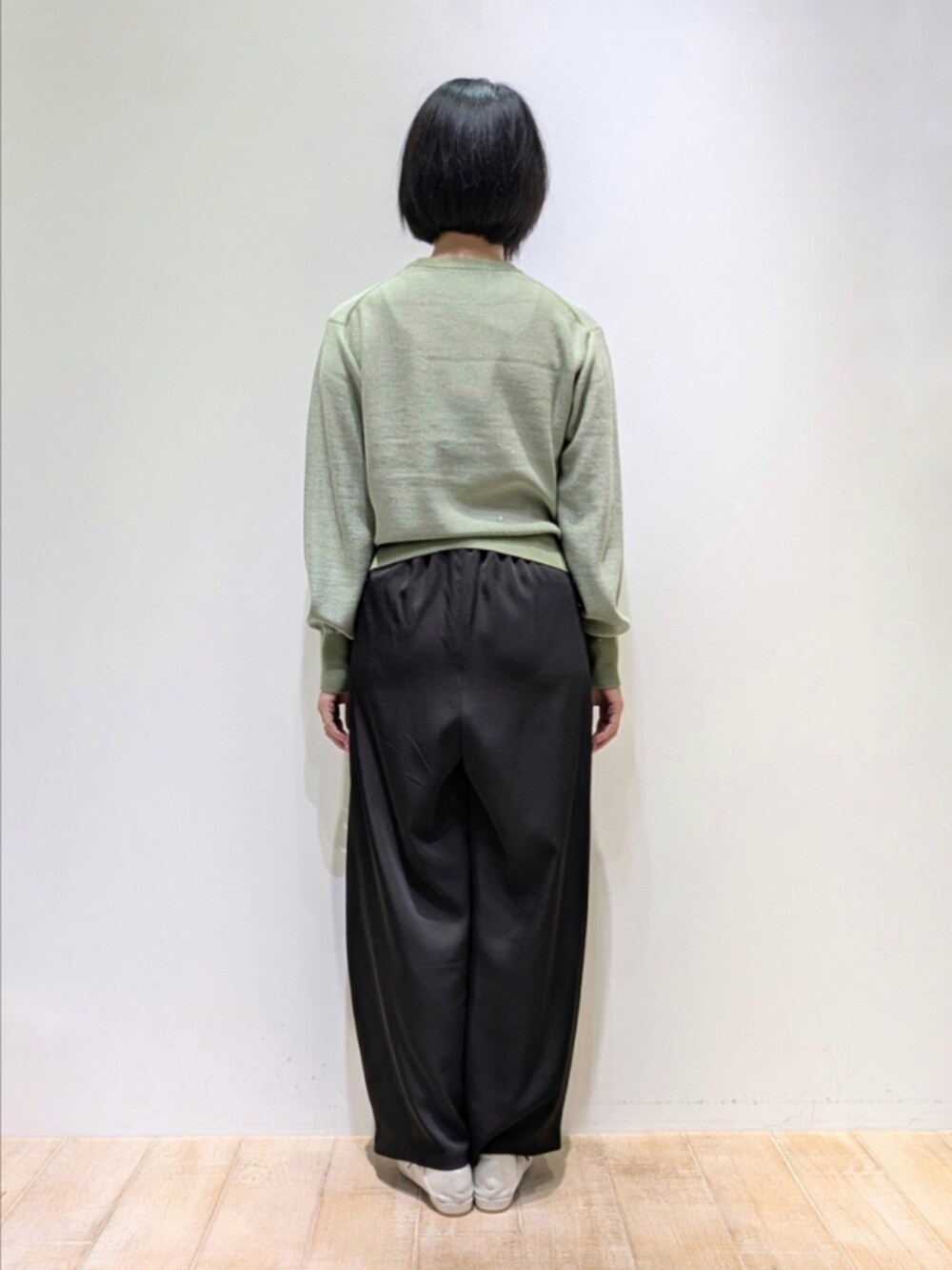 グリーン系のニット/セーター、ブラック系のその他パンツを着用したレディースの秋コーディネートの5枚目の写真