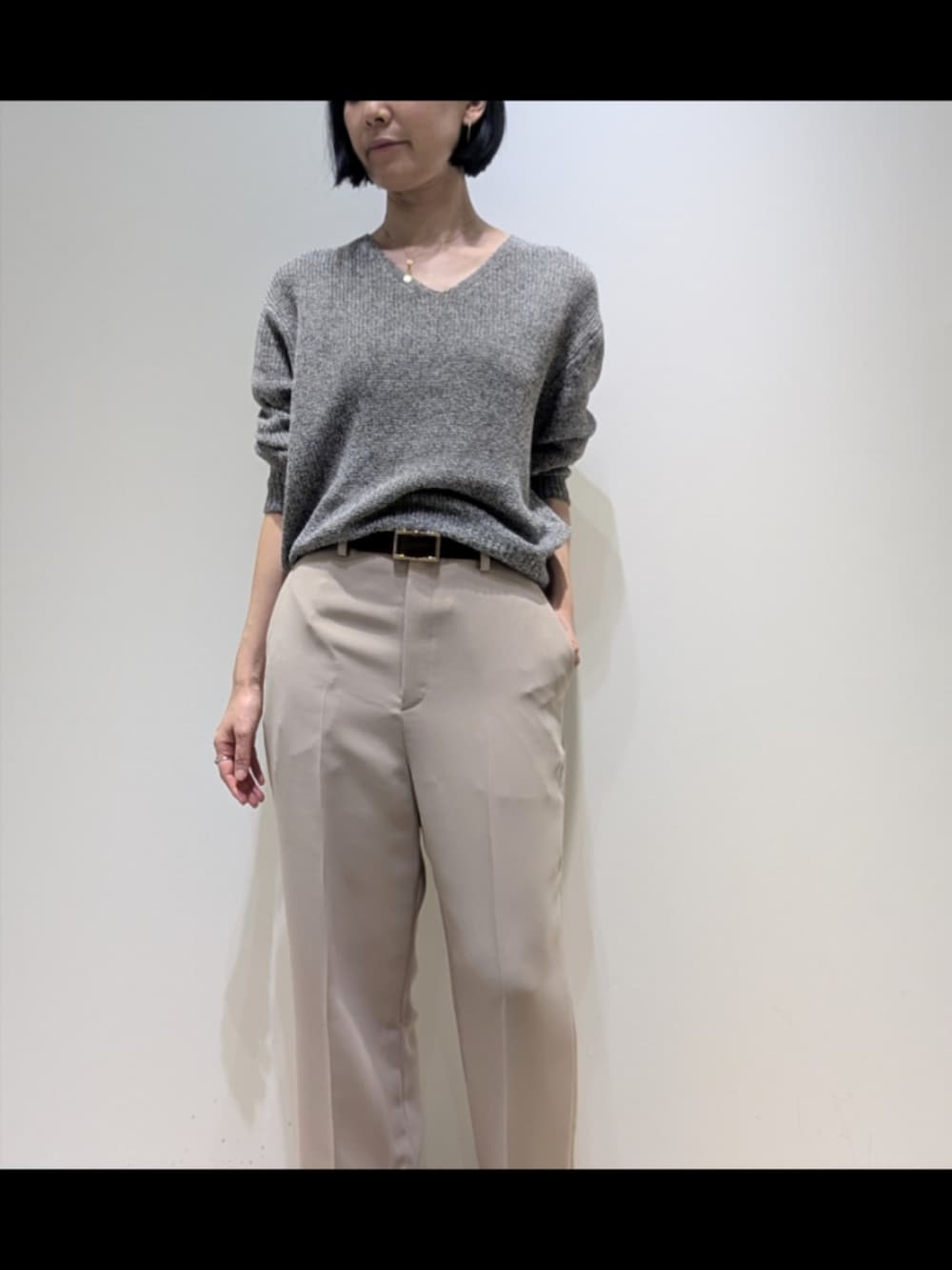 グレー系のニット/セーター、ベージュ系のその他パンツ、ブラウン系のベルトを着用したレディースの冬コーディネートの2枚目の写真