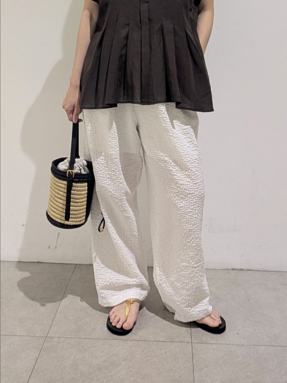 ブルー系のニット/セーター、ホワイト系のその他パンツ、シルバー系のネックレスを着用したレディースの夏コーディネートの3枚目の写真