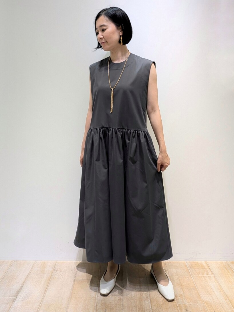 グレー系のワンピース、ゴールド系のネックレスを着用したレディースの夏コーディネートの5枚目の写真