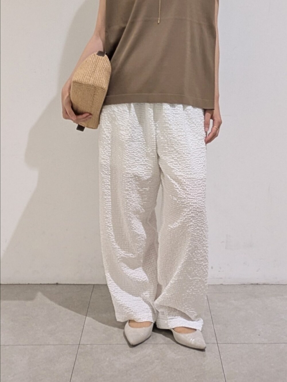 グレー系のニット/セーター、ホワイト系のその他パンツ、ゴールド系のネックレスを着用したレディースの夏コーディネートの3枚目の写真