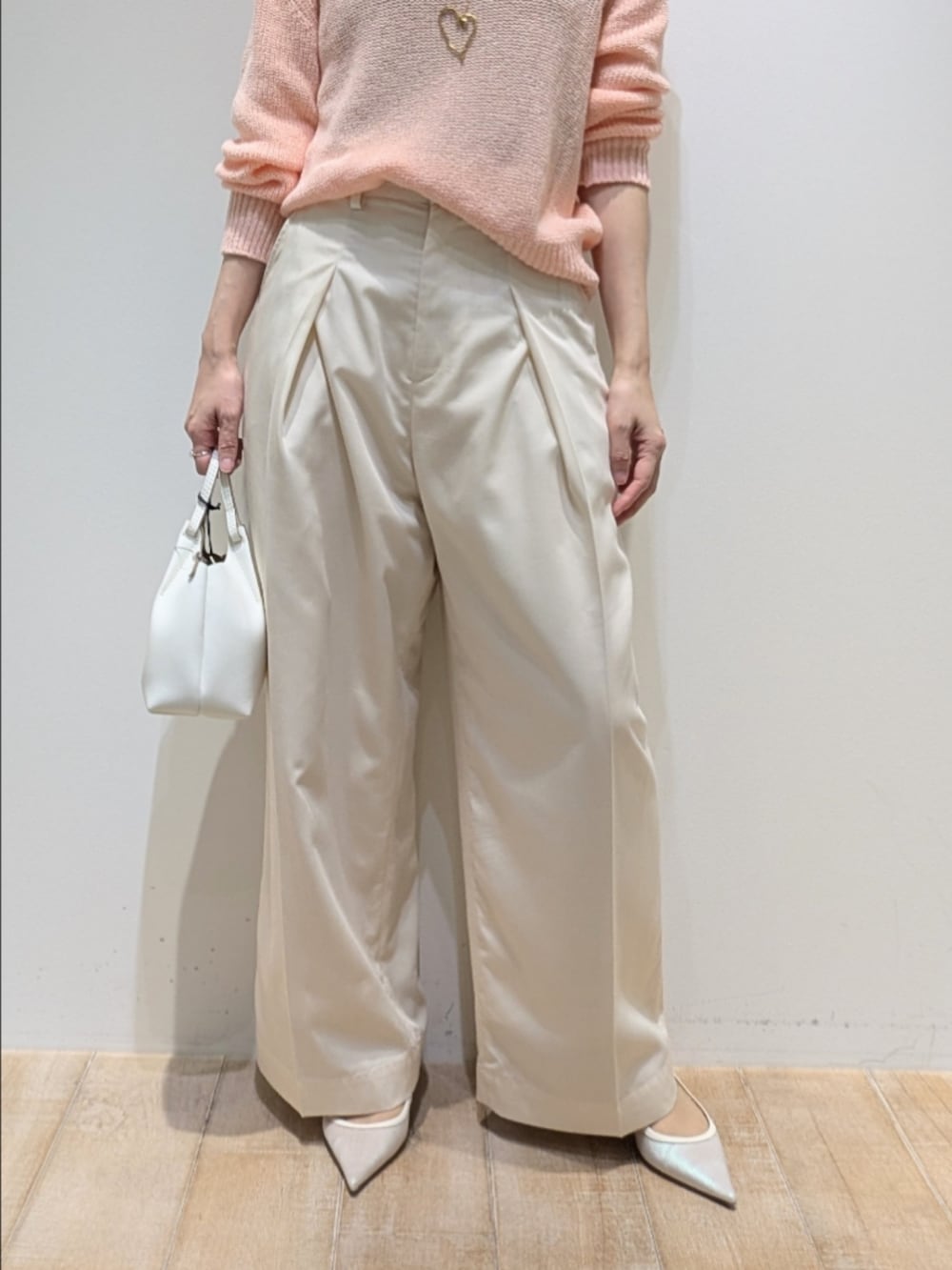 ピンク系のニット/セーター、ホワイト系のその他パンツを着用したレディースの春コーディネートの3枚目の写真