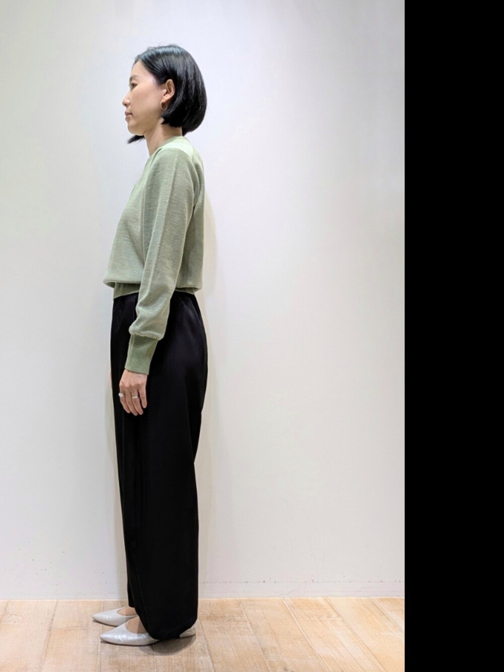 グリーン系のニット/セーター、ブラック系のその他パンツを着用したレディースの秋コーディネートの4枚目の写真