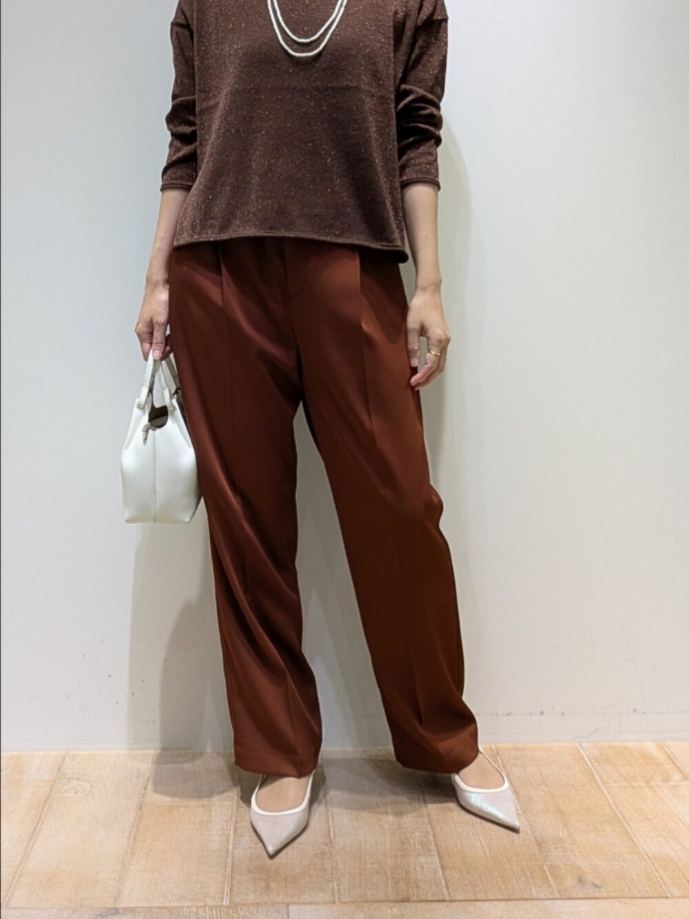 ブラウン系のその他パンツ、その他のニット/セーター、ホワイト系のネックレスを着用したレディースの秋コーディネートの3枚目の写真