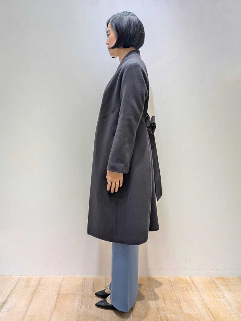 グレー系のチェスターコート、ブルー系のスラックス、ホワイト系のニット/セーターを着用したレディースの冬コーディネートの2枚目の写真