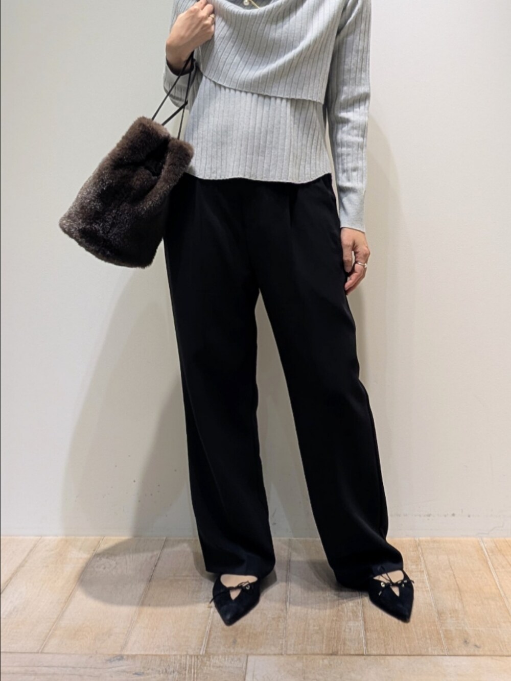 ブルー系のニット/セーター、ブラック系のその他パンツ、ブラウン系のショルダーバッグを着用したレディースの冬コーディネートの3枚目の写真