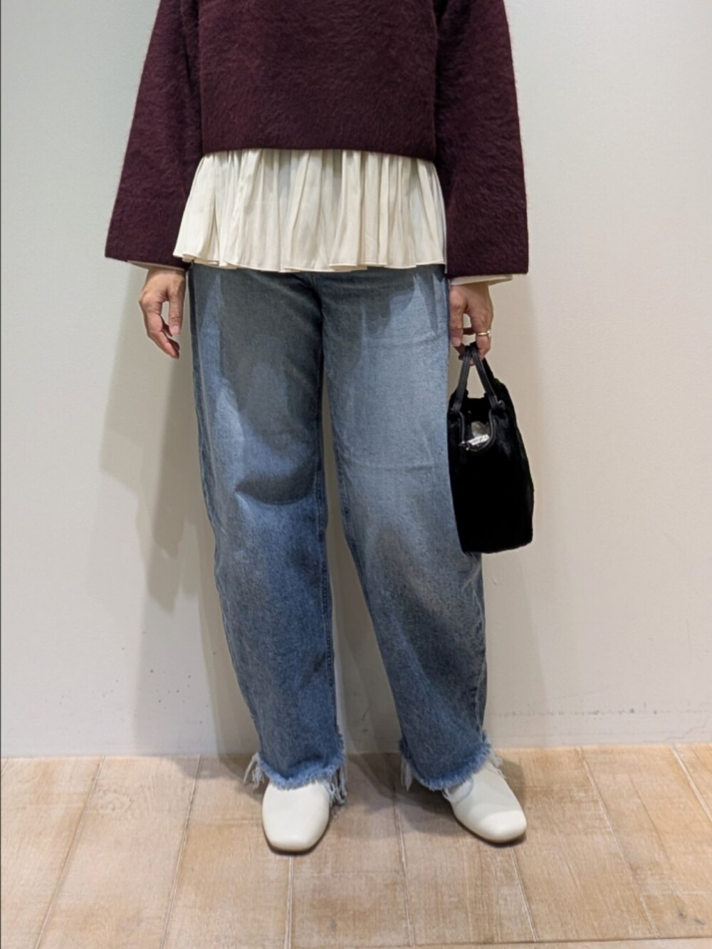 レッド系のニット/セーター、ホワイト系のシャツ/ブラウスを着用したレディースの冬コーディネートの3枚目の写真