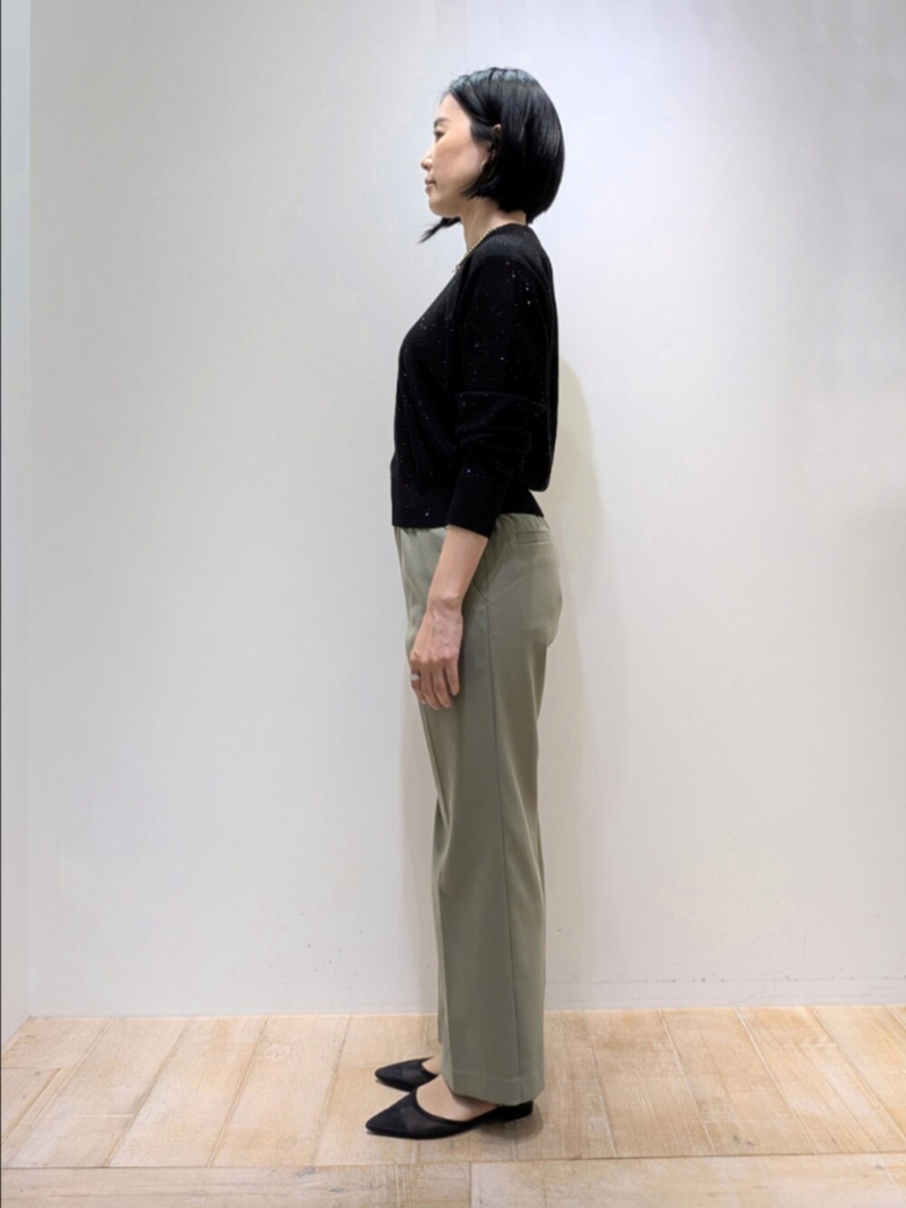 ブラック系のニット/セーター、グリーン系のその他パンツ、グリーン系のショルダーバッグを着用したレディースの秋コーディネートの4枚目の写真