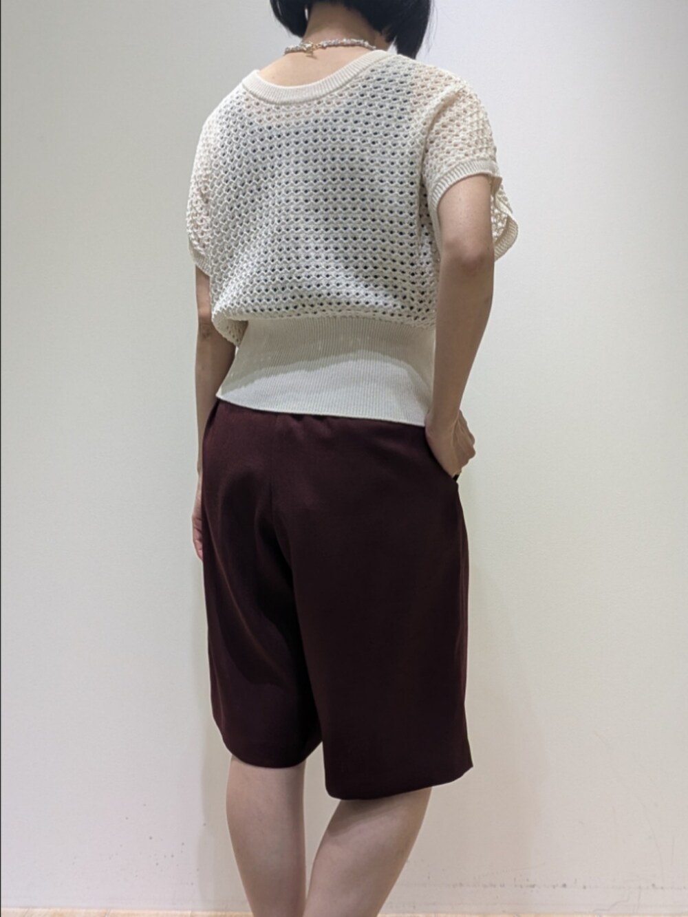 レッド系のその他パンツ、ホワイト系のニット/セーター、ホワイト系のネックレスを着用したレディースの春コーディネートの5枚目の写真
