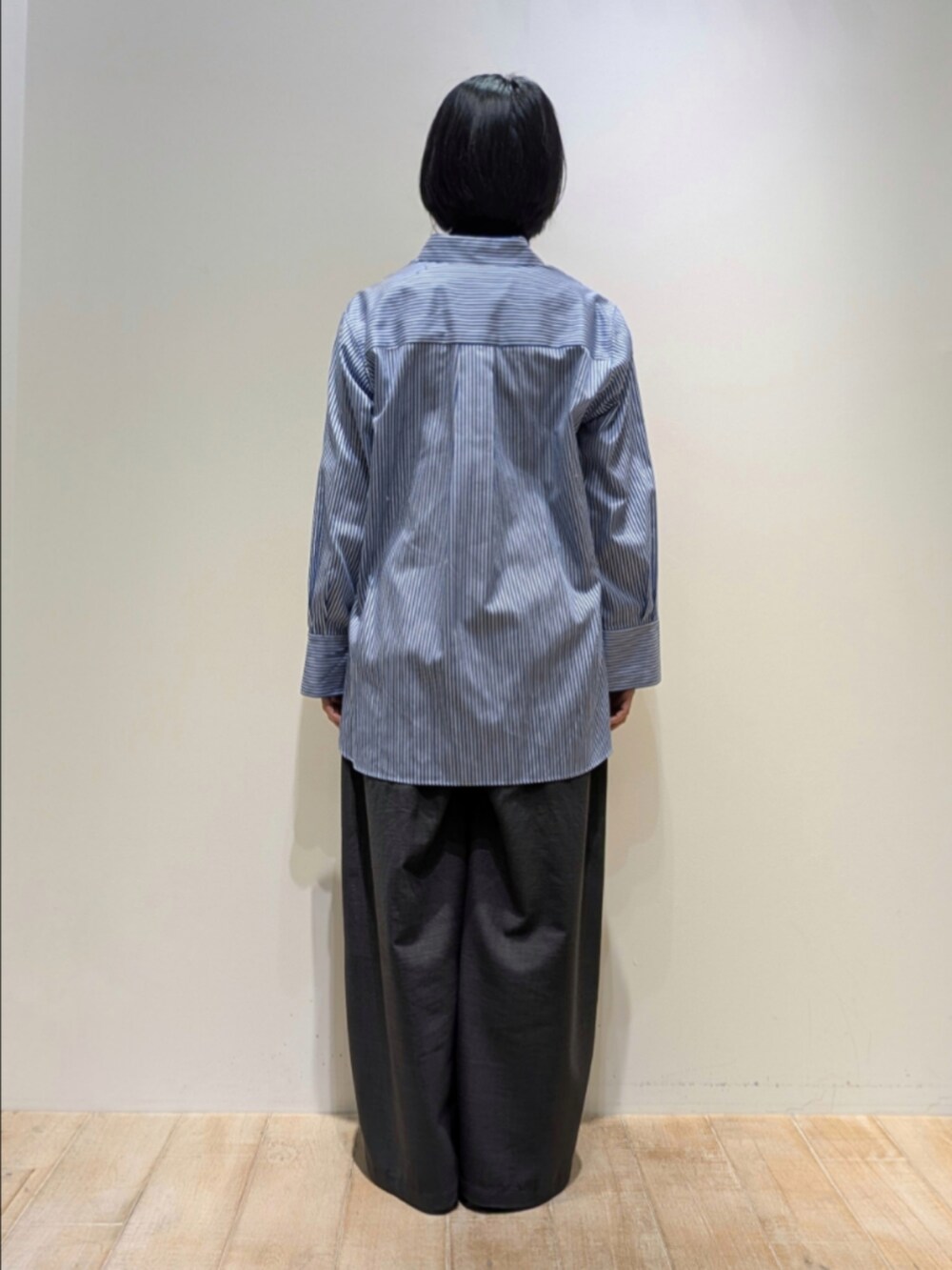 ブルー系のシャツ/ブラウス、ブラック系のニット/セーター、グレー系のその他パンツを着用したレディースの秋コーディネートの5枚目の写真