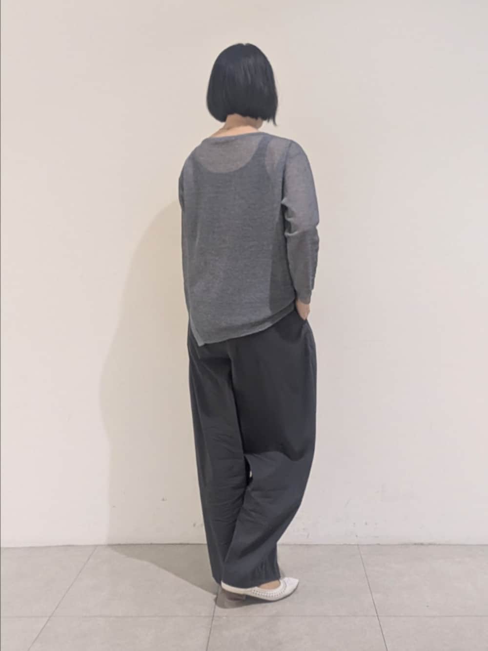ブルー系のニット/セーター、グレー系のその他パンツ、シルバー系のネックレスを着用したレディースの夏コーディネートの5枚目の写真