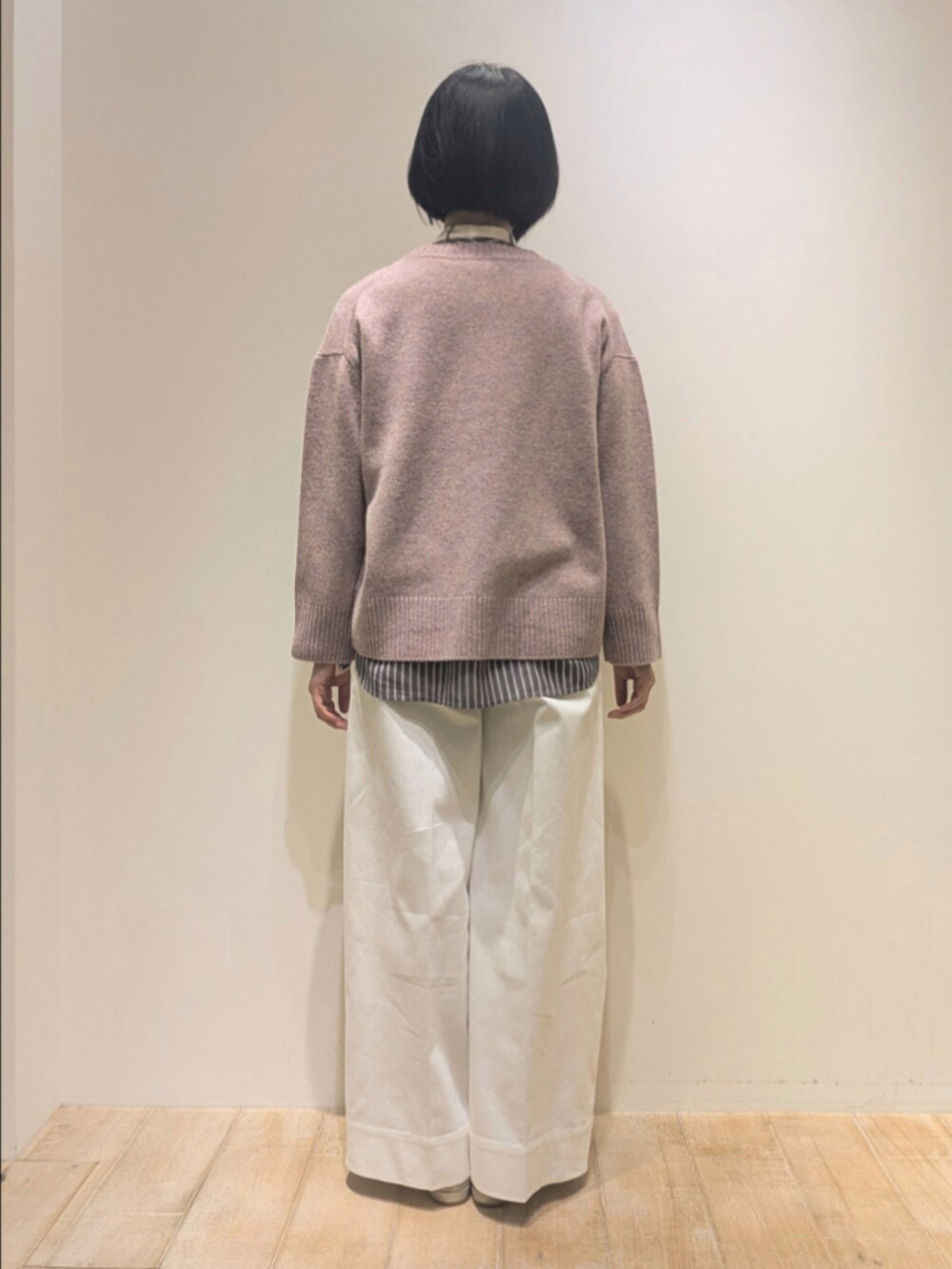 ピンク系のニット/セーター、ブラック系のシャツ/ブラウス、ホワイト系のデニムパンツを着用したレディースの冬コーディネートの5枚目の写真